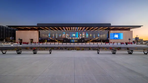 Plaza and glass entrance of an arena at dusk