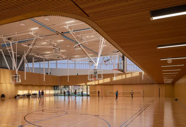 Community gymnasium under a curved wood ceiling