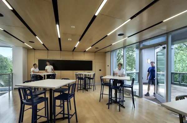 Students at high-top tables in a timber-ceilinged lounge