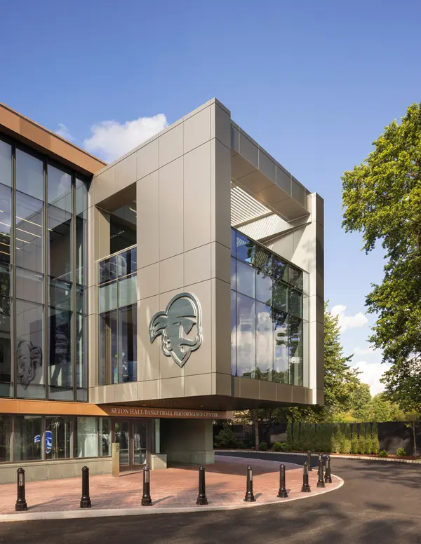 Glass-and-metal athletics building with a pirate logo on its facade