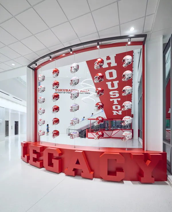 Red HOUSTON legacy display wall lined with football helmets