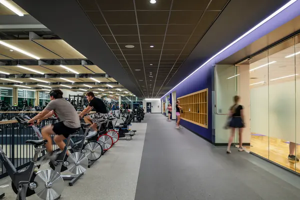 Students riding bikes in a long fitness corridor
